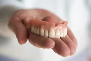Full Upper Denture on a patient's palm Full Upper Denture on a patient's palm