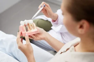 patient being shown the dental implant model patient being shown the dental implant model