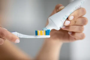 putting toothpaste on toothbrush putting toothpaste on toothbrush